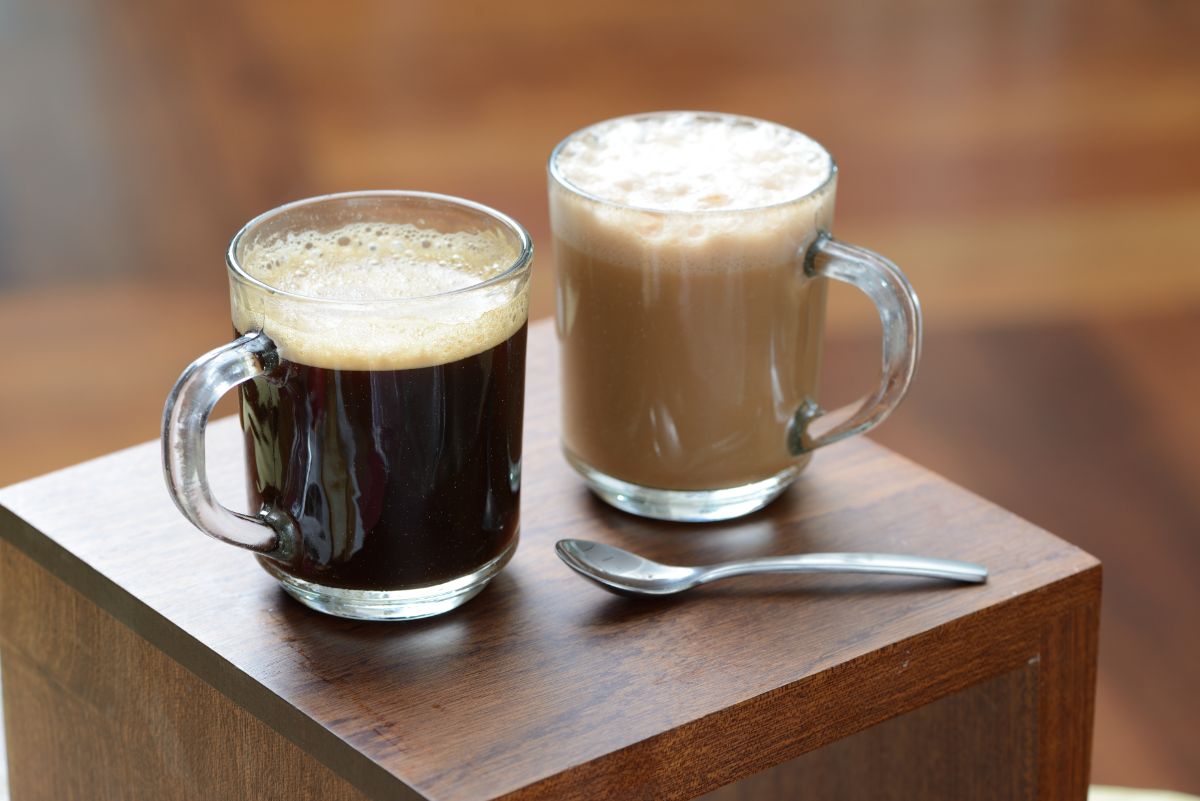 Glass cups of coffe with spoon on table.