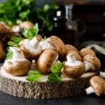 Fresh organic mushrooms on wooden board on black table.