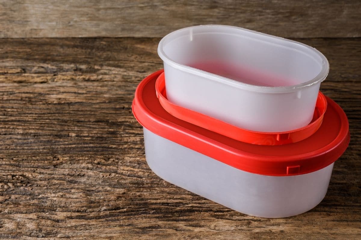 Empty tupperware plastic containers on wooden table.