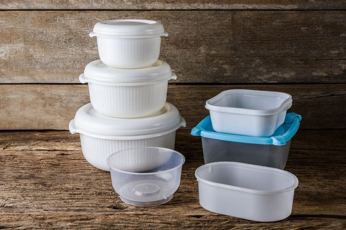 Empty tupperware plastic containers on wooden table.
