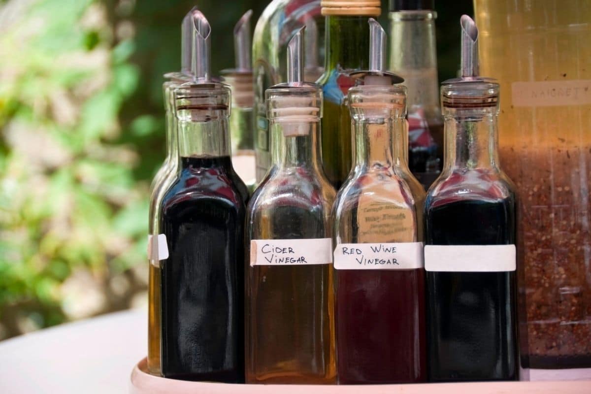 Glass bottles of different types of vinegar on table.