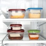 Plastic containers with leftovers in refrigerator.