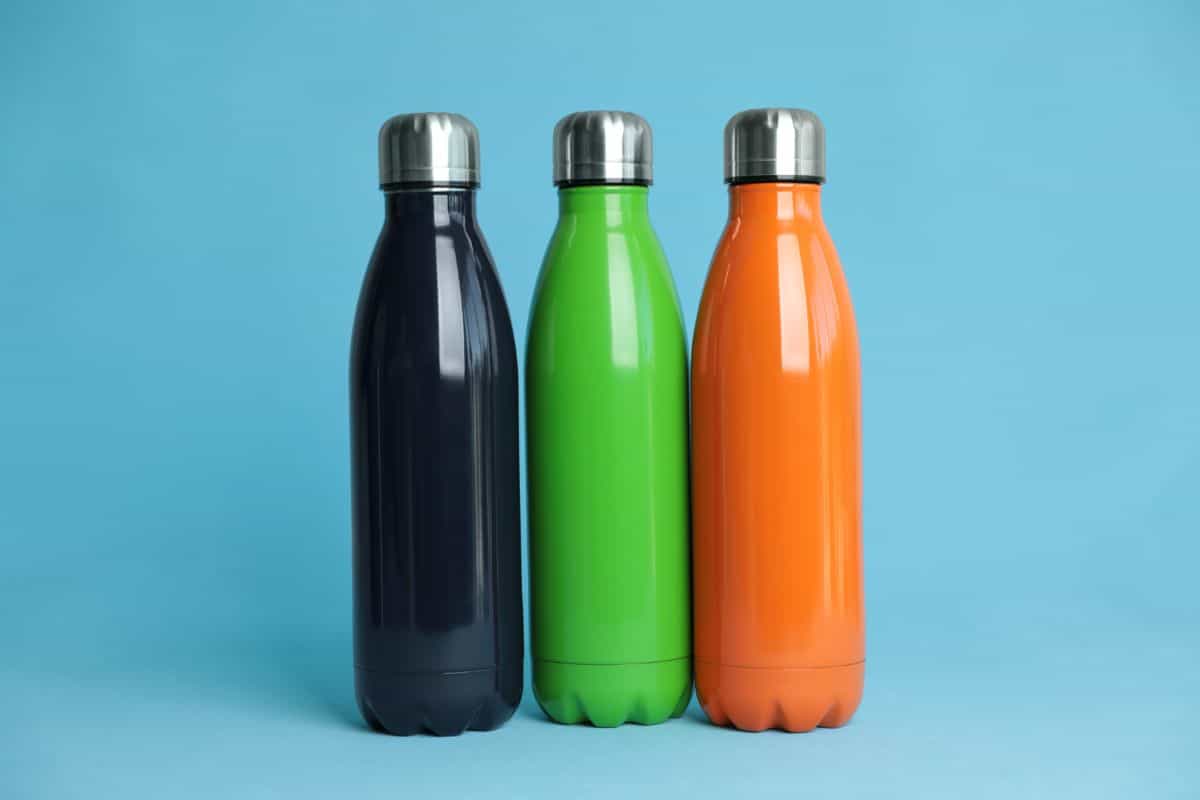 Three thermo bottles on blue background.