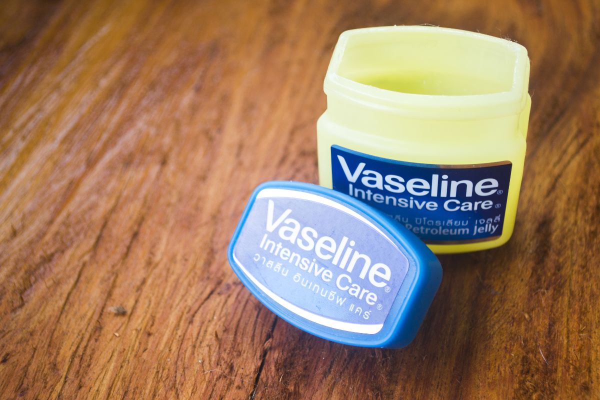 Open jar of vaseline on wooden table