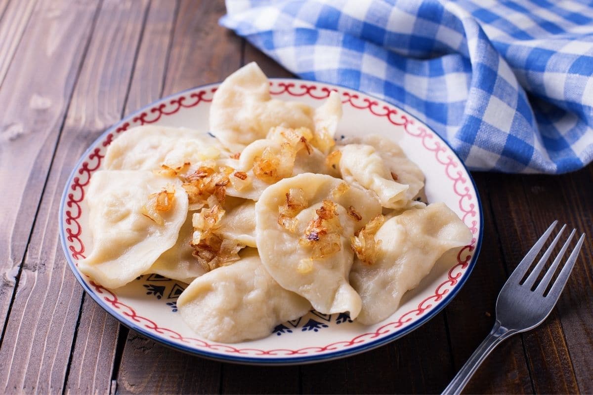 Plate of fresh homemade dumplings on wooden table