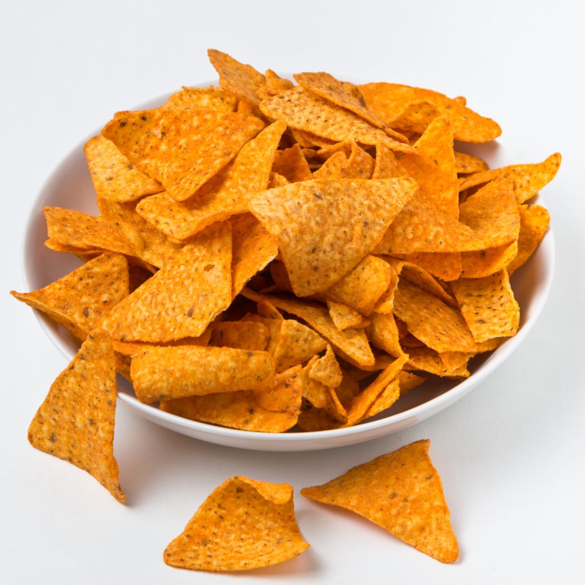 White bowl of doritos on white background