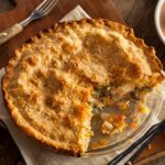 Pot pie on glass tray on wooden board with cloth wipe