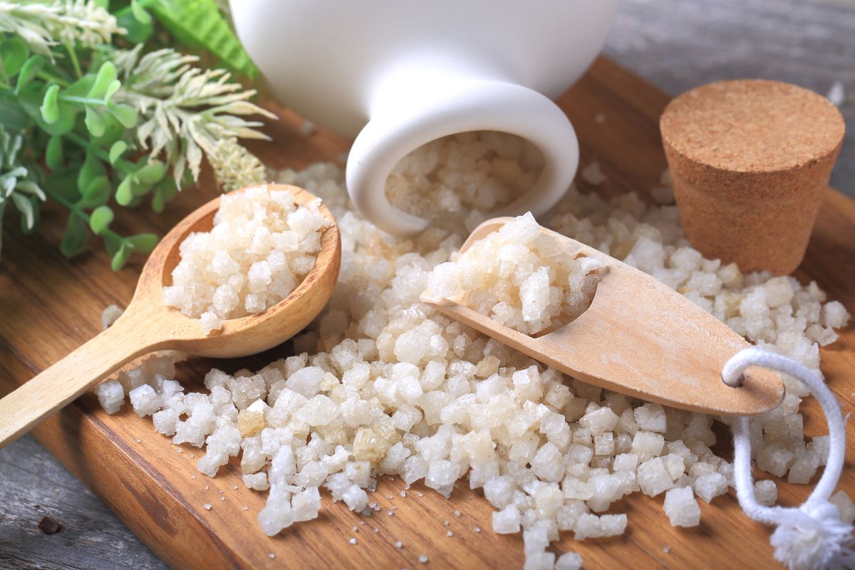 Epsom salt on wooden board with wooden spoon poured from jar