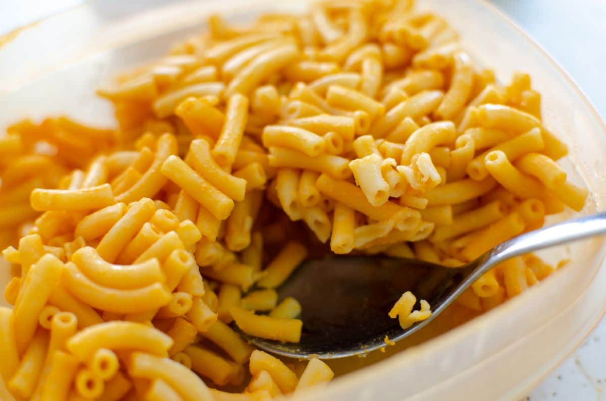 Mac and cheese with spoon in plastic container