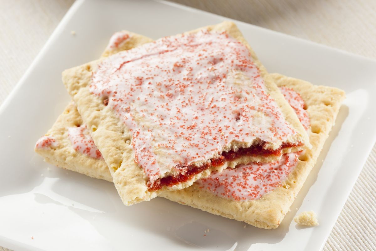 Strawberry pop-tarts one half bitten on white plate