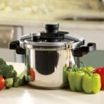 Mircowave pressure cooker with vegetable on white table
