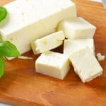 Slices of feta cheese on wooden cutting board
