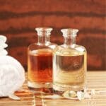Glass jars of massage oil on table