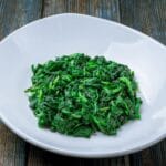 Steamed spinach on white plate
