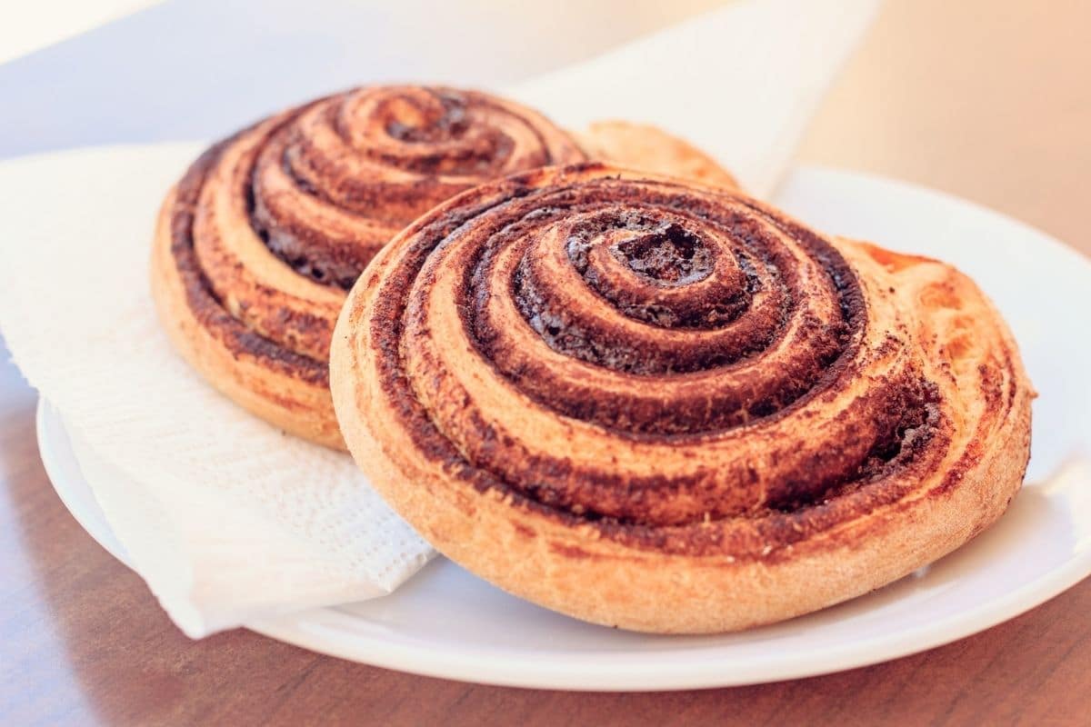 Cinnamon rolls on white plate with napkin
