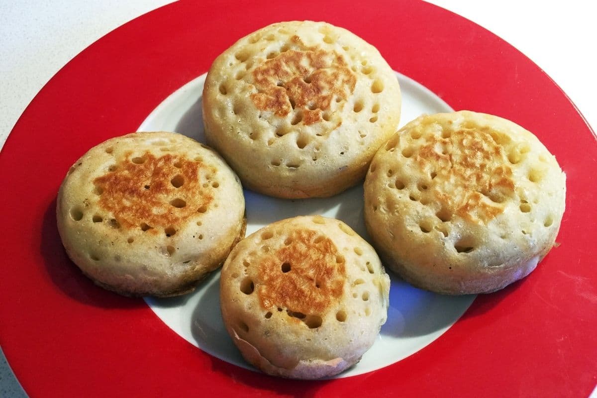 Fresh crumpets on red-white plate