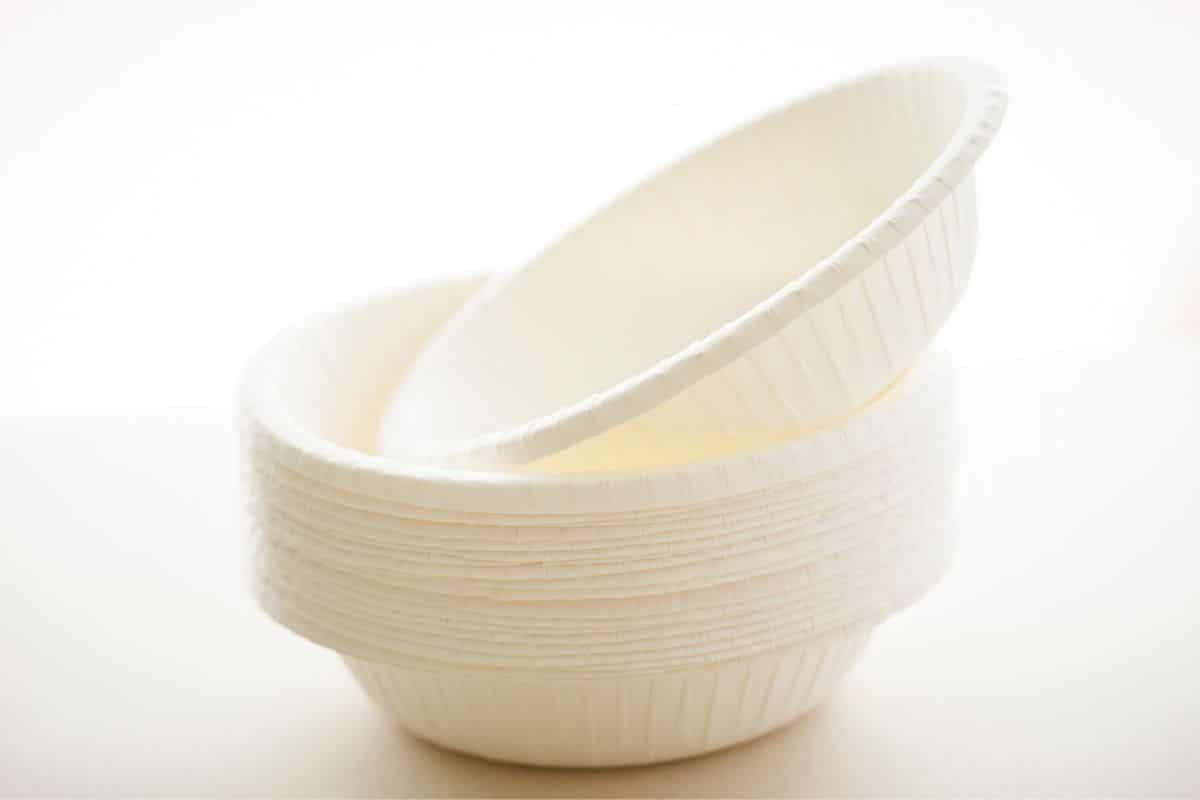 Pile of white paper bowls on white background