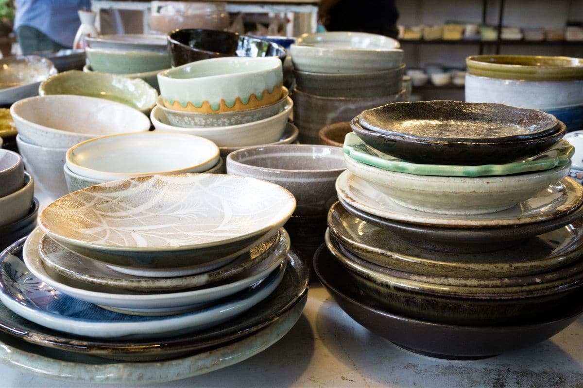 Piles of porcelain plates and bowls on table