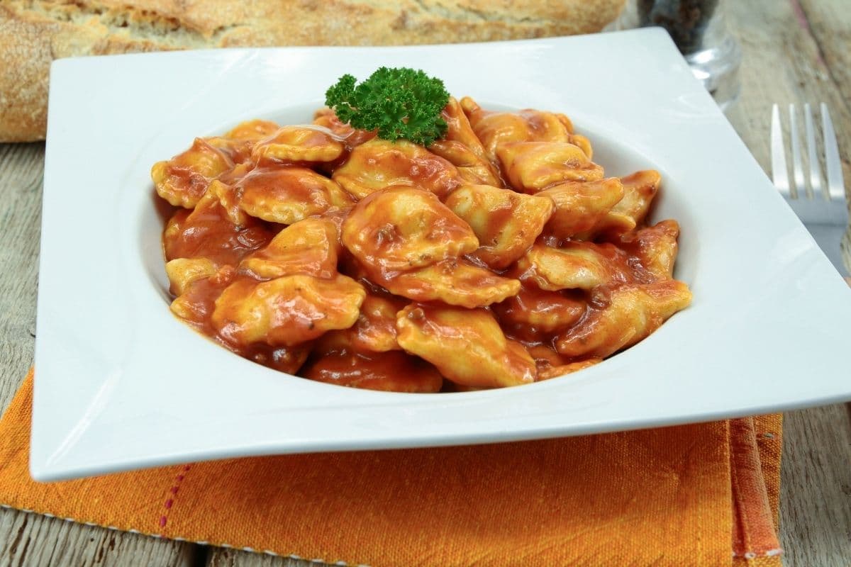 Ravioli dish with herb on white plate