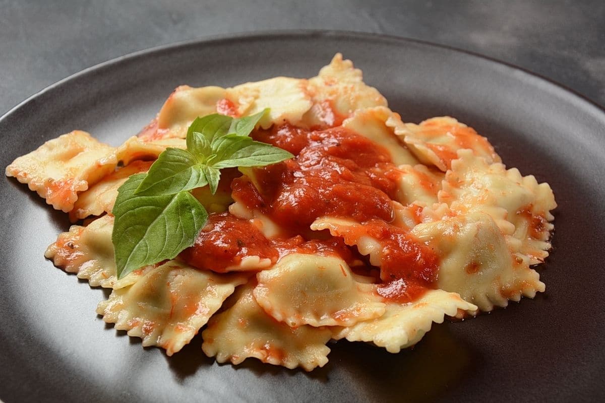 Ravioli dish with herb on black plate