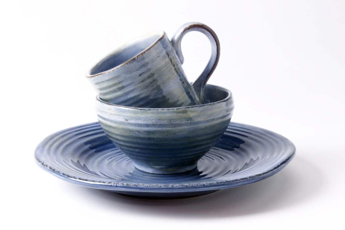 Stoneware blue cup, bowl and plate on white background