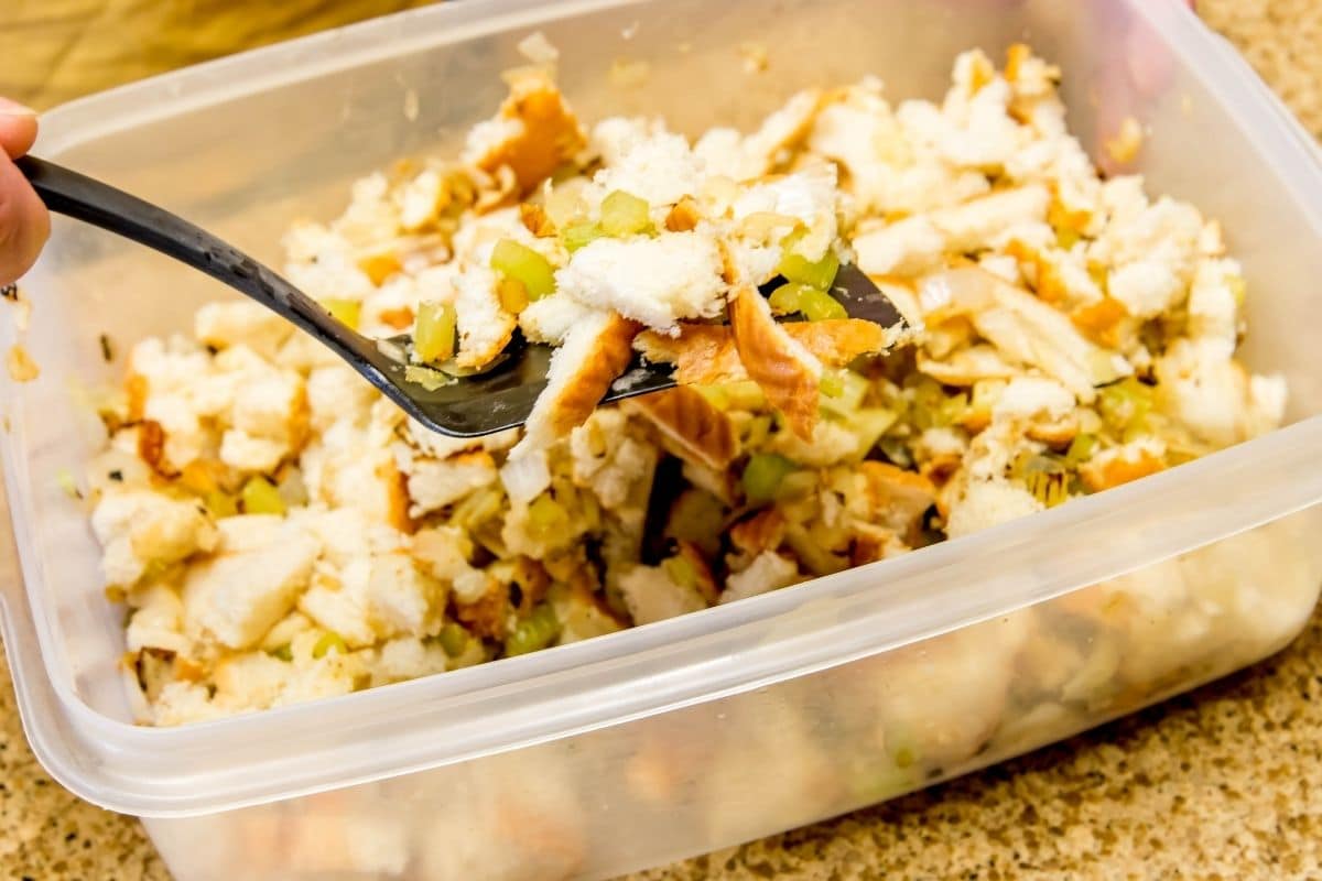 Stuffing mix picked up by fork in plastic container