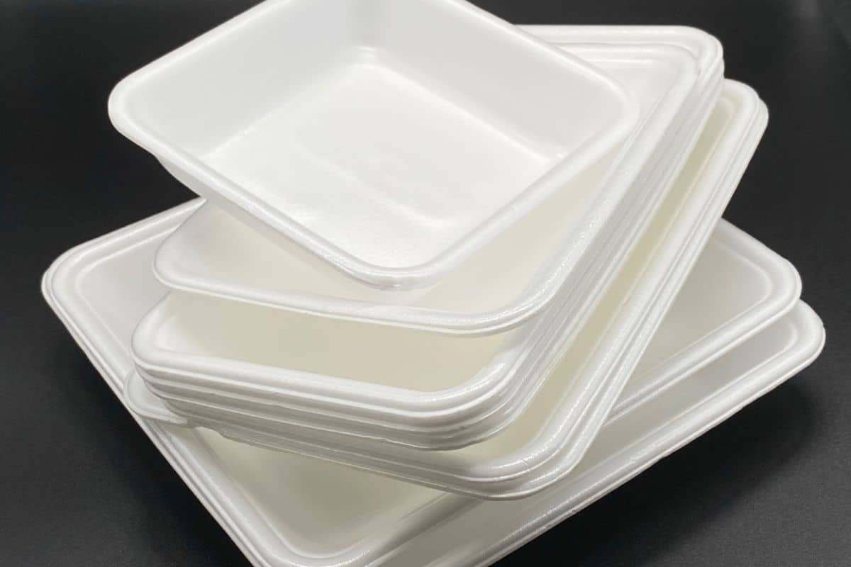 Pile of styrofoam plates on black background