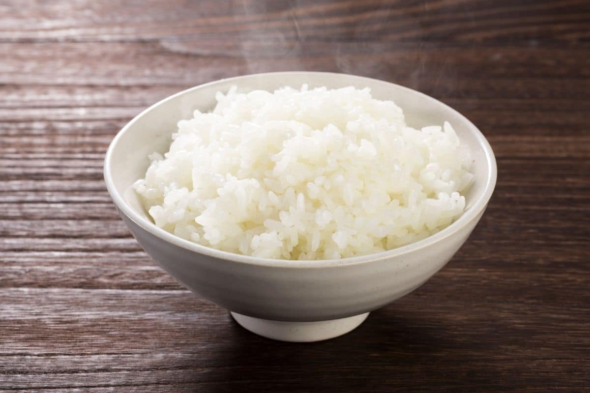 Bowl of white rice on wooden table