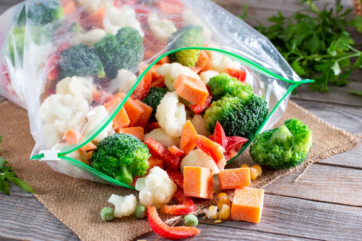 Open bag of frozen vegetables on a table.