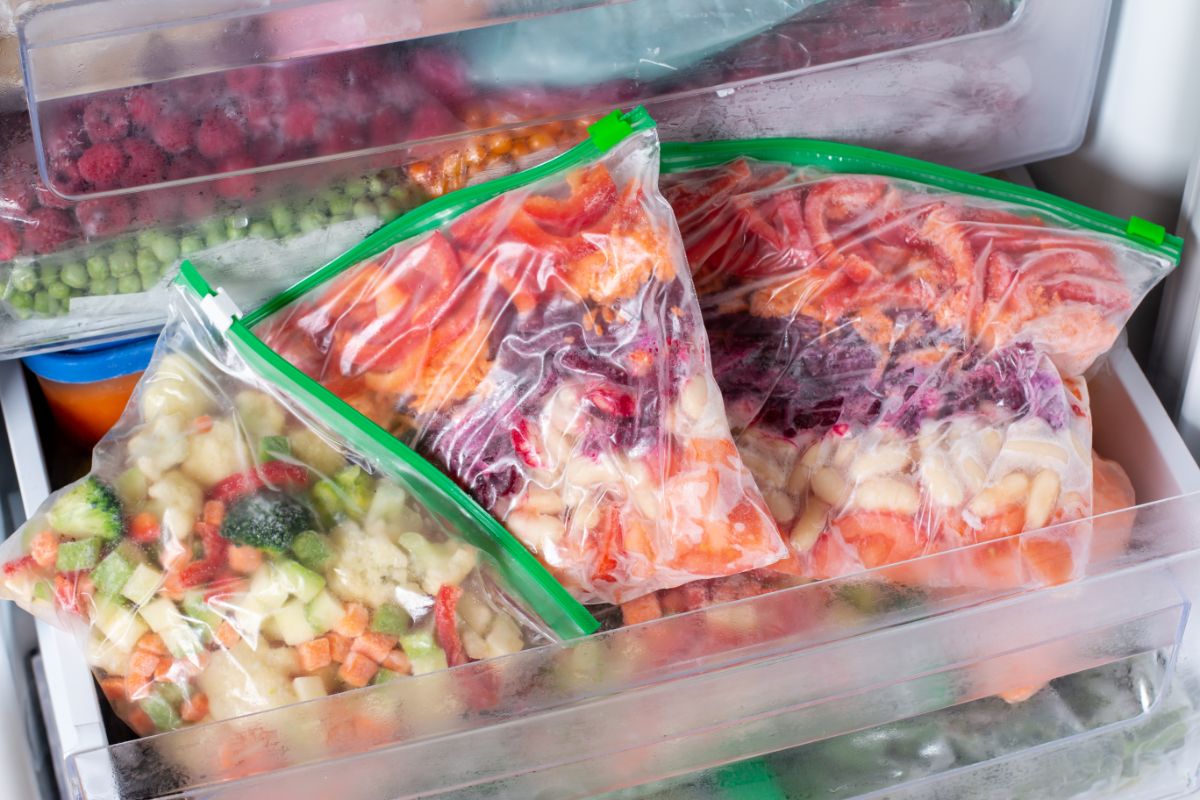 Bunch of frozen vegetable bags in a freezer shelf.