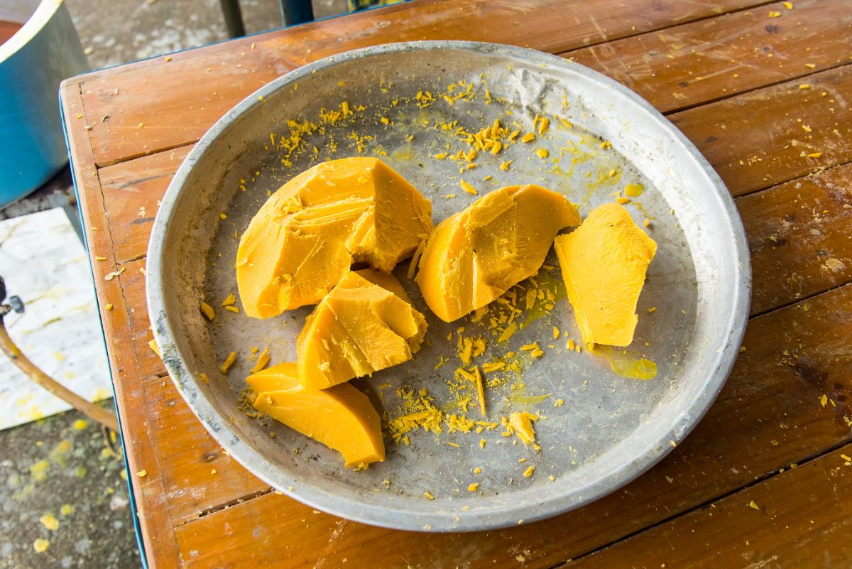 Piece of natural bee wax in a bowl on a table.