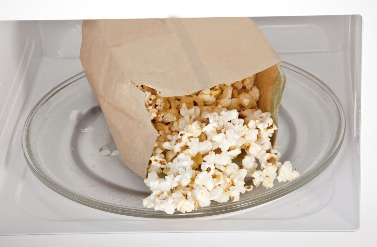 Paper bag of popcorn in a microwave.