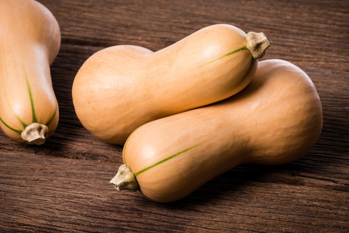 Whole butternut squashes on a wooden table.