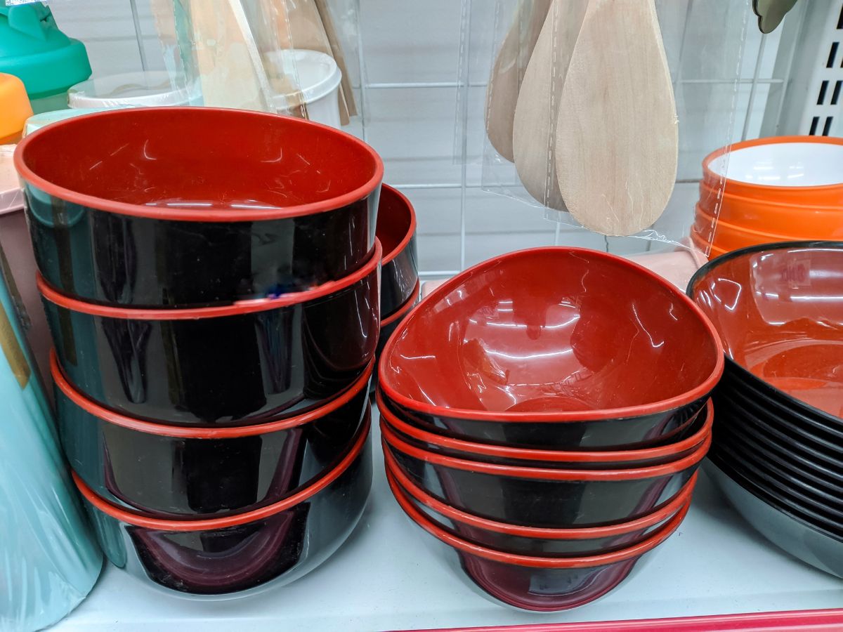 Stacks of melanine bowls and plates in a kitchen.