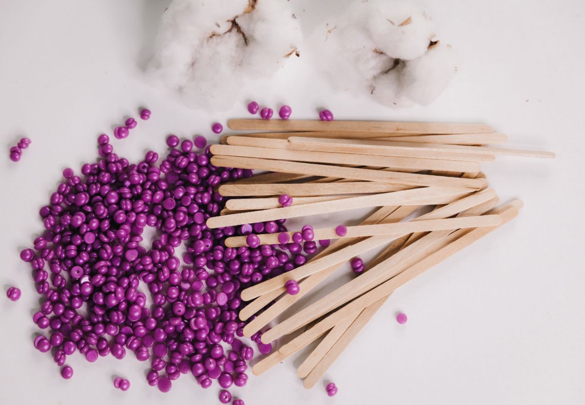 Purple wax beads with wooden stripes on a table.