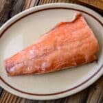 A frozen salmon fillet on a plate.