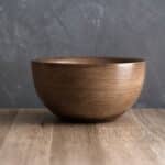 A wooden bowl on a wooden table.