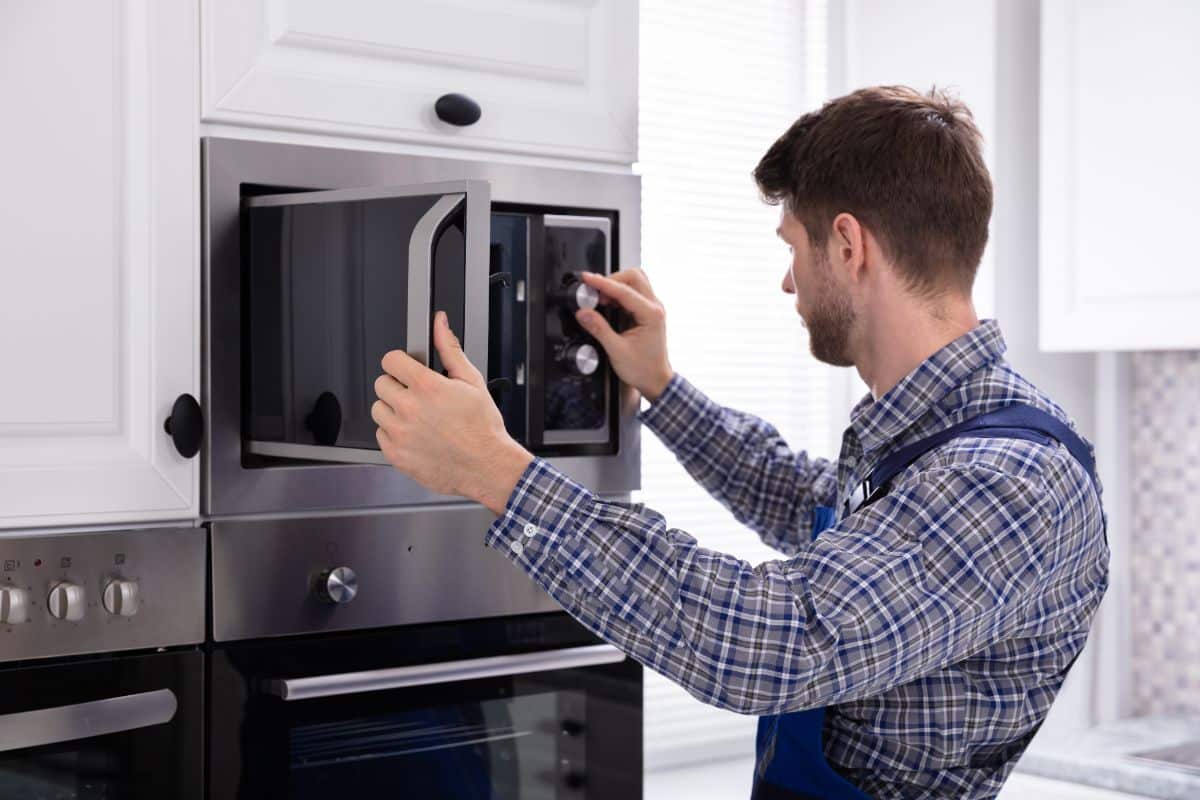 A technician checking a microwave.