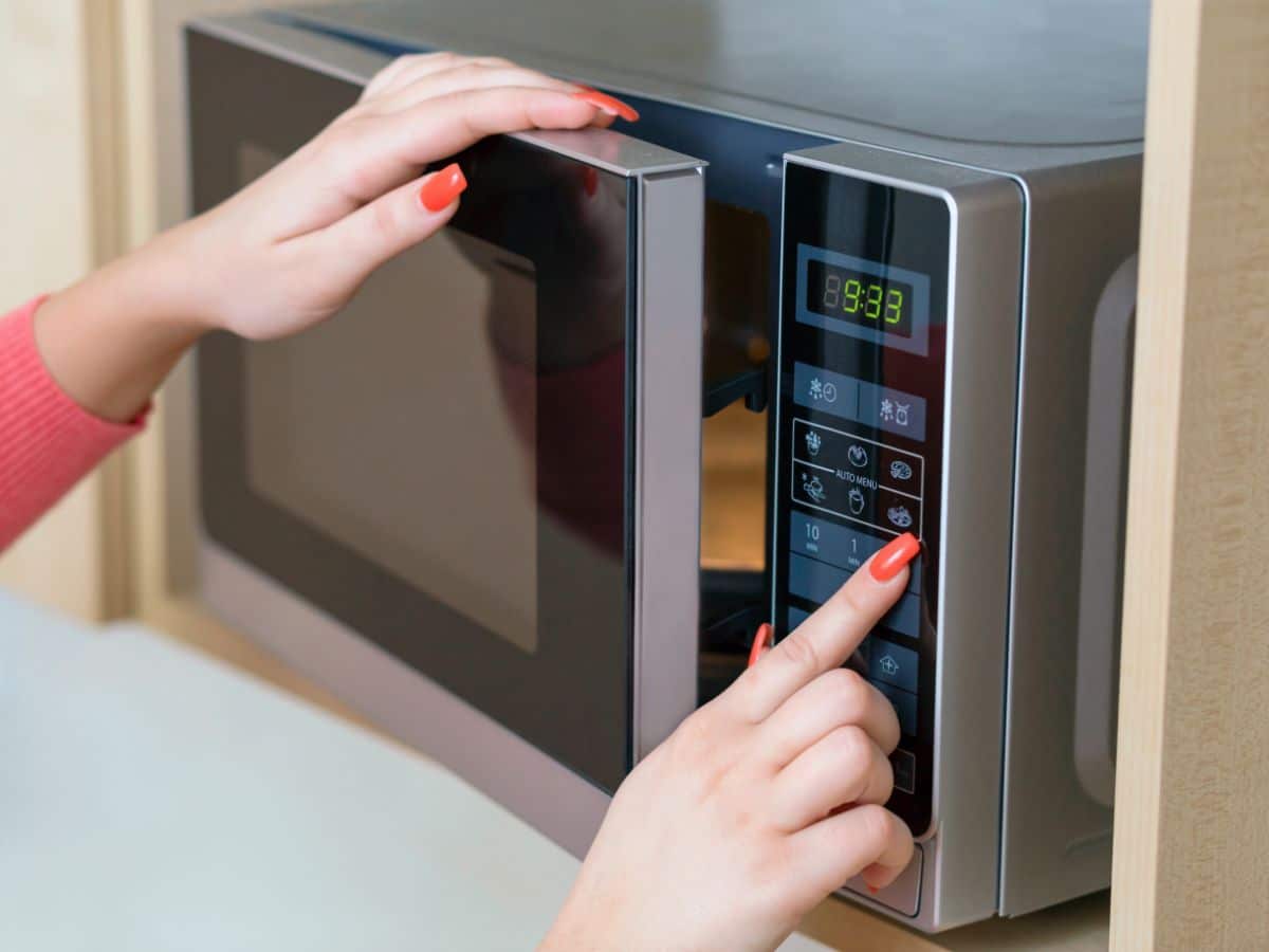 A woman setting up a microwave.
